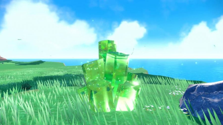 ポケモン スカーレットとバイオレット テラ レイド バトル: 緑の結晶が草で覆われた表面に表示され、エネルギーで輝いています。