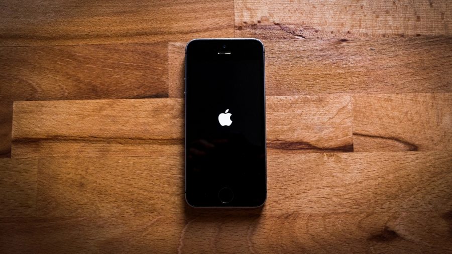 iPhoneでアルバムを削除する方法 - 木製の床に置かれたiPhone