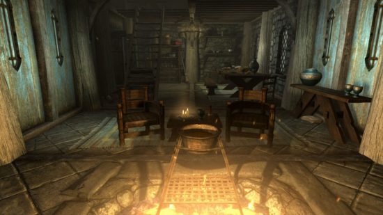 Skyrim の結婚: Skyrim のスクリーンショットで、その周りに椅子が置かれ、その上に鍋が置かれた古風な家の真ん中にファイヤー ピットが置かれました。