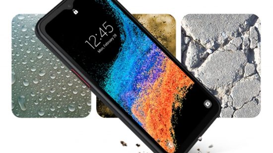 最高の頑丈な携帯電話の 1 つである Samsung Xcover6 Pro は、青と赤の砂地の背景と画面に時刻が表示され、空中に斜めに浮かんでいます。 黒です。