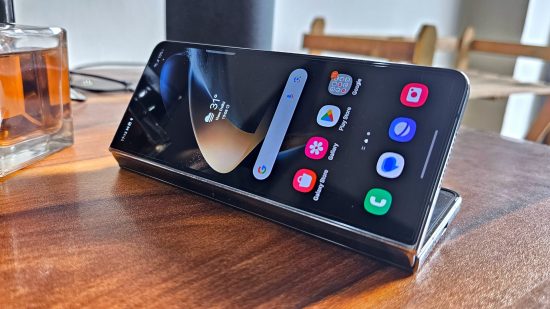 Samsung Galaxy Z Fold 4 レビュー - 半分に折り畳んで木製のテーブルの上に置いた携帯電話の写真 